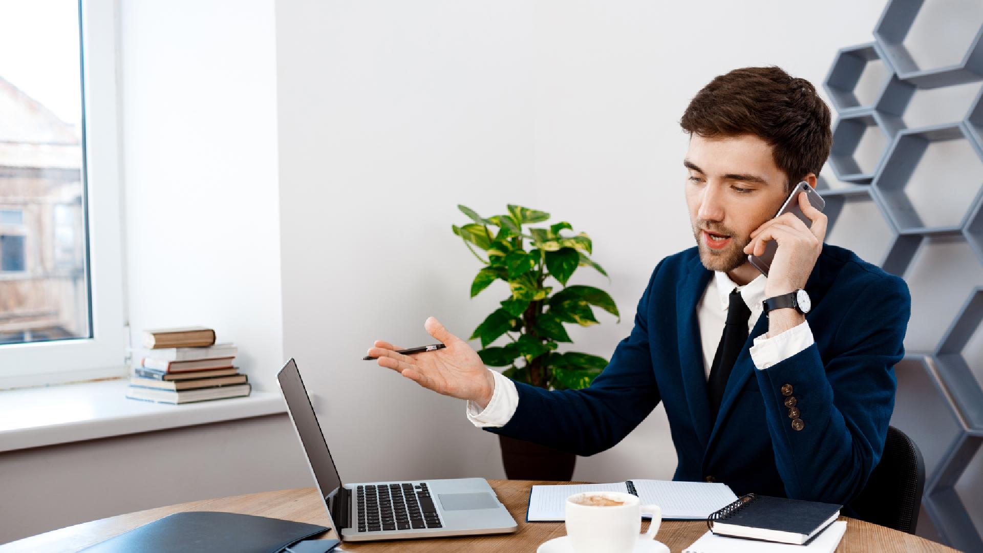 young-successful-businessman-speaking-phone-office-background-1